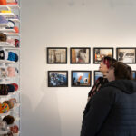 Two students look at artwork during the Student Juried Art Exhibition