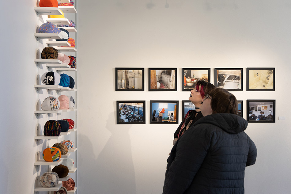 Two students look at artwork during the Student Juried Art Exhibition