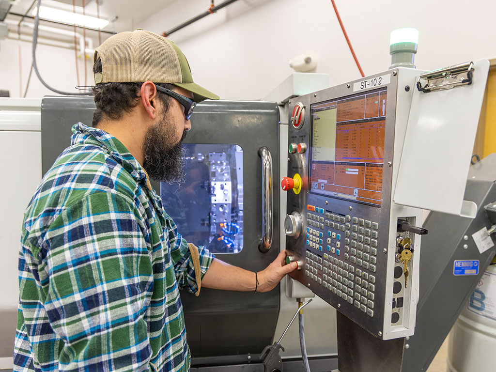 Photo of Sheridan College student working on CNC machine