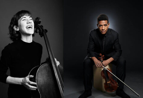 Josh and Julia Henderson, Julia with a cello laughing and Josh holding his violin.