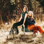 Edie Carey and Sarah Sample photo, outside sitting together on a chair in the grass