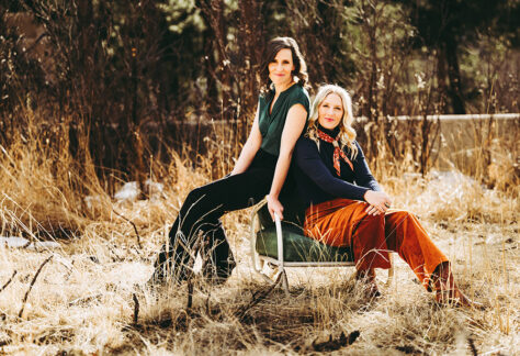 Edie Carey and Sarah Sample photo, outside sitting together on a chair in the grass