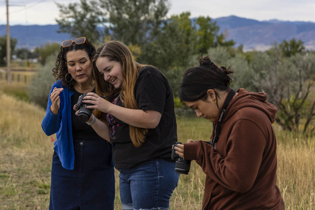 Students look at the photos they've taken using the preview screen on the back of their cameras