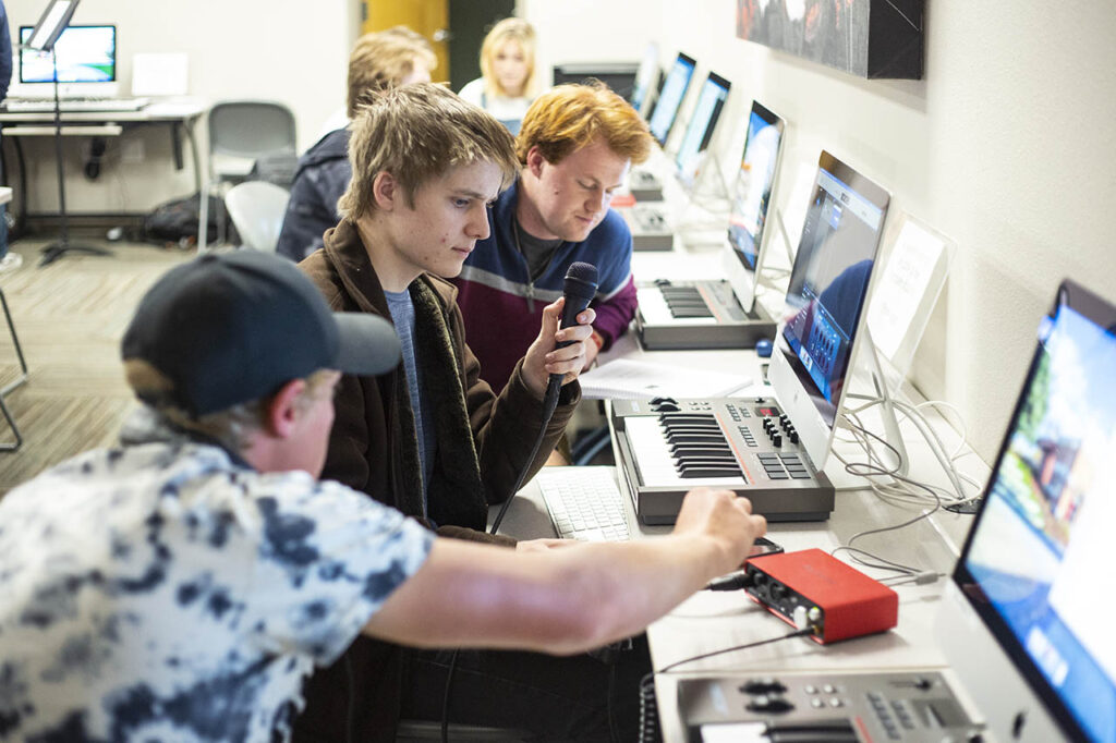 Students working on a project with a microphone in the music tech lab