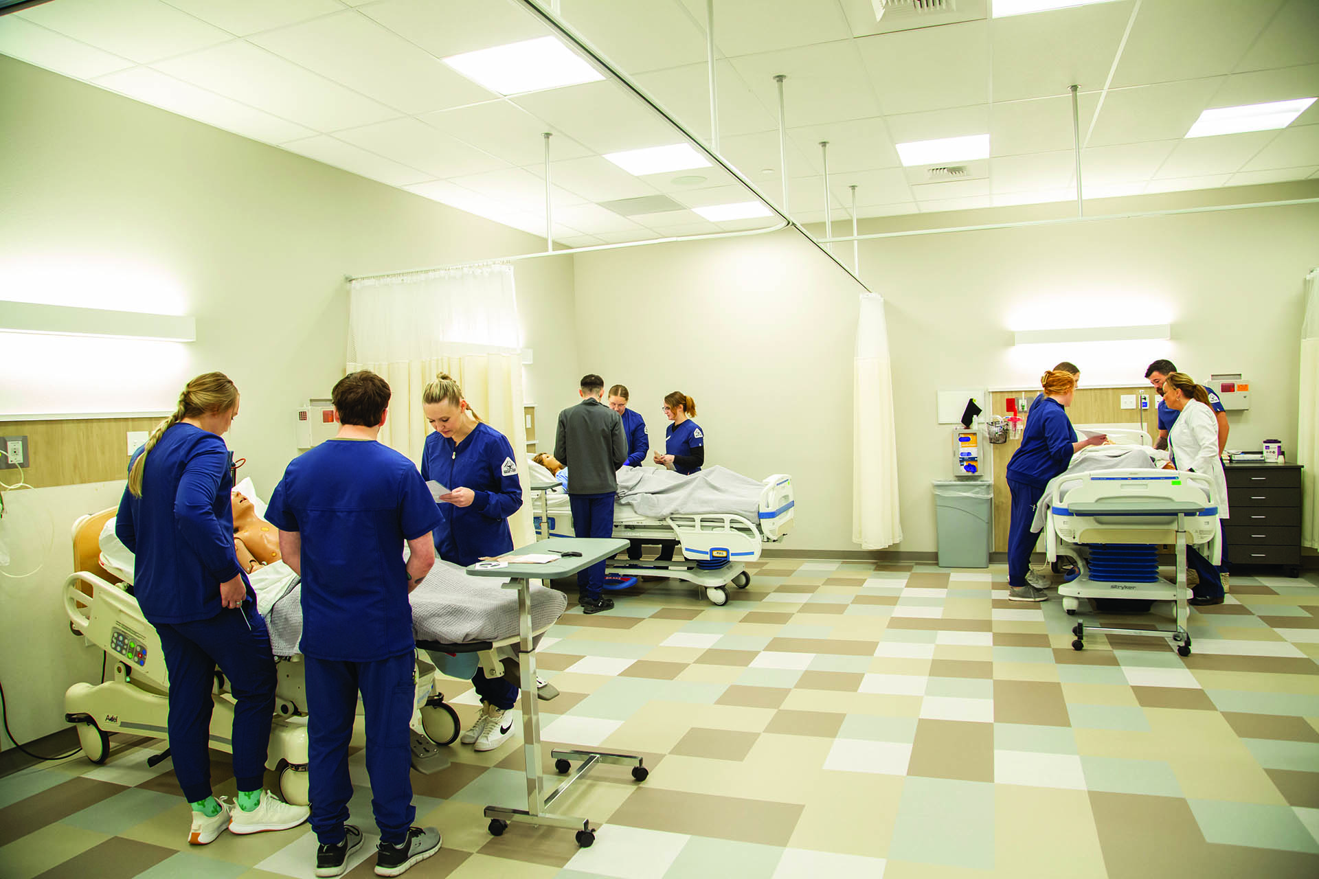 Sheridan College nursing stationed at three different beds that have manikins working through a simulation exercise