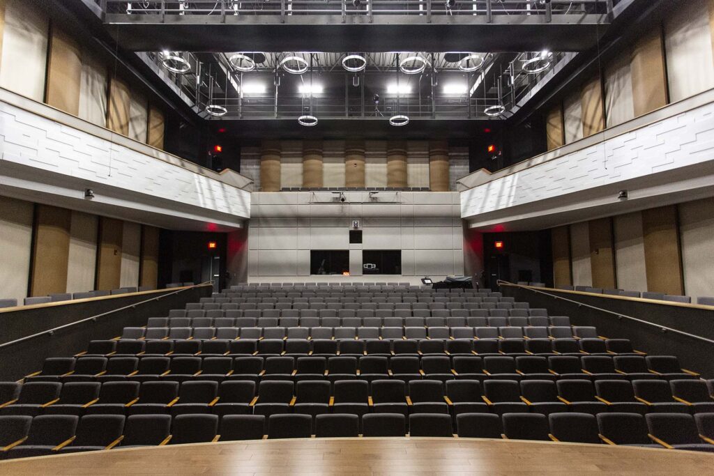 Looking back inside Kinnison Hall up at the lights and second floor and all the seats