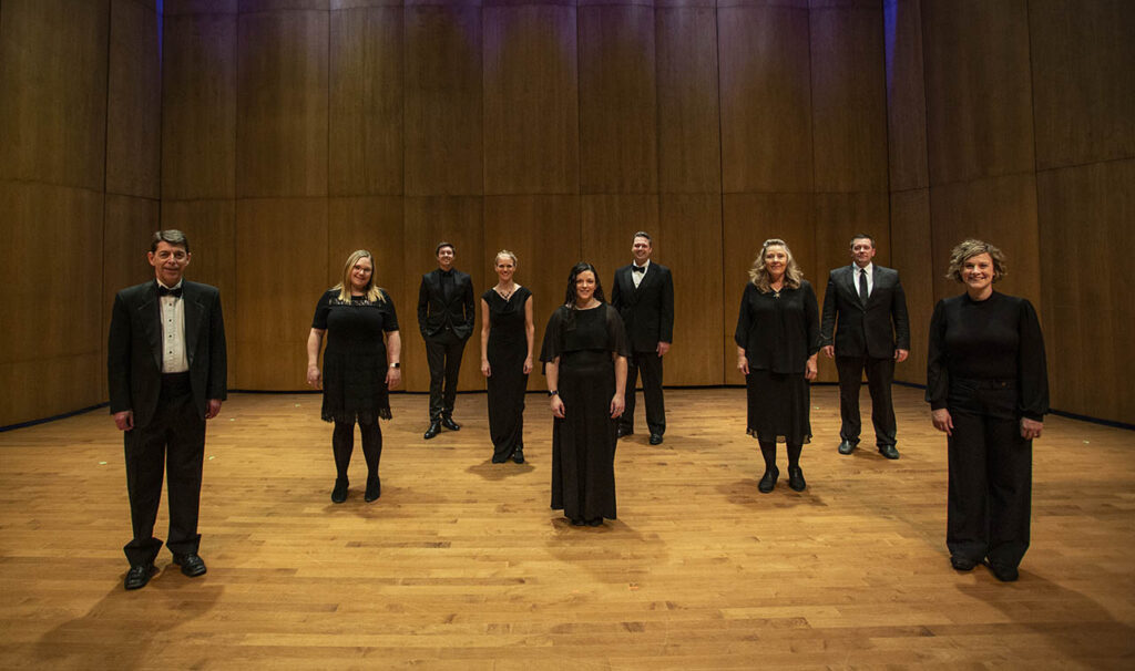 Skyline Singers portrait of 10 singers spaced out on the stage at Kinnison Hall