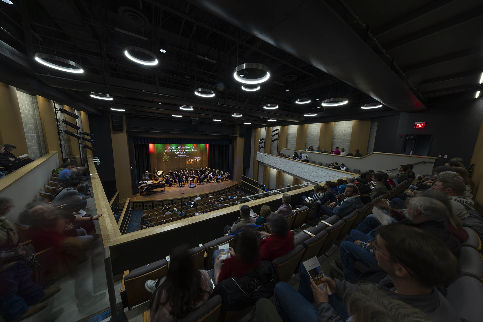 Image of Kinnison Hall from the upstairs balcony with the hall full of audience members as they watch the holiday swing performance by SC bands and jazz ensembles