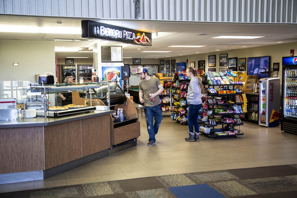 Students browsing in the convenience store and Bighorn Pizza counter at Sheridan College